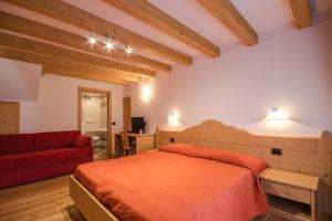 拉比方塔宁旅馆的一间卧室配有一张床和一张红色的沙发