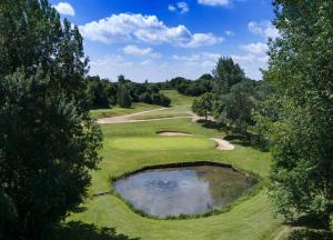伍德布里奇Ufford Park Resort的高尔夫球场的顶部景色,设有池塘