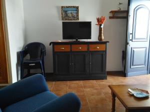 法马拉Casa la Caleta的客厅配有电视和蓝椅