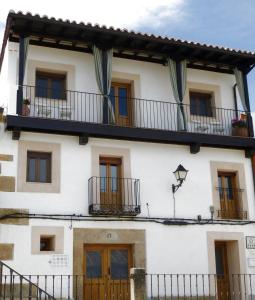 夸科斯德尤斯特Apartamentos Rurales Entre Fuentes的白色的建筑,设有窗户和阳台