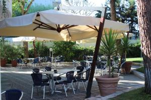 巴里维多利亚公园酒店 的一个带桌椅和遮阳伞的庭院