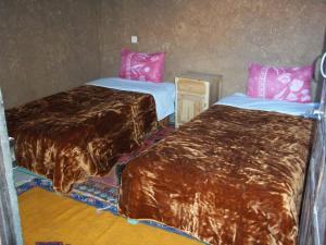 Foum ZguidAuberge L'Oasis的配有两张床垫的酒店客房内的两张床
