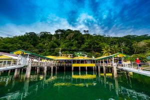 戈尔菲托香蕉湾码头酒店的水面上有一个黄色和绿色建筑的码头