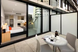 悉尼圣伦纳兹探索公寓的配有一张床和一张桌子及椅子的房间