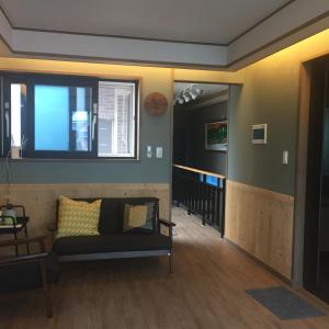 木浦市达尔古梅旅馆的带沙发和窗户的客厅