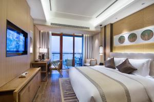 文昌文昌温德姆至尊豪廷大酒店的酒店客房设有一张大床和一台电视。