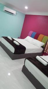 瓜拉勿述伊兹村庄酒店的色彩缤纷的墙壁内的两张床