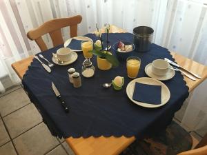 辛斯海姆Hotel Gästehaus Sonne的一张桌子,上面有蓝色桌布,盘子和饮料