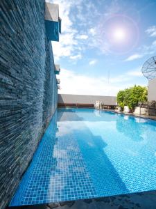 曼谷维新安睡酒店的一座建筑物边的蓝色瓷砖游泳池