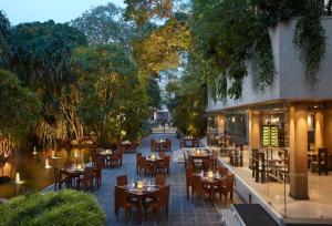 科伦坡肉桂大科伦坡酒店的户外餐厅设有桌椅和树木