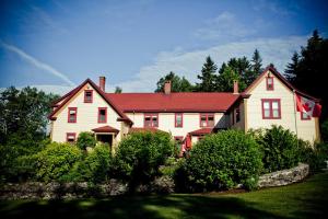 BocabecDominion Hill Country Inn的一座大型白色房屋,设有红色屋顶