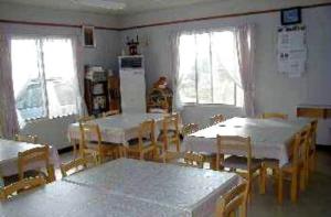 网走市Abashiri Ryuhyou no Oka guesthouse的用餐室设有桌椅和窗户。
