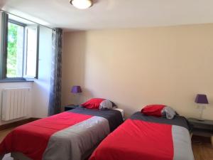 拉卡佩勒－维耶斯康La Grange du Lac de Cantalès的红色和灰色的客房内的两张床