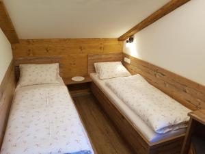 格罗萨尔Hoamalm的小型客房的两张床,设有木墙