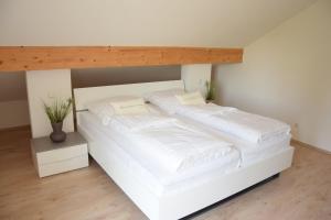 巴特比恩巴赫Ferienwohnung Leni的配有2张床的带白色床单和枕头的客房