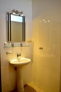 罗威那罗密简易别墅的浴室配有盥洗盆和带镜子的淋浴
