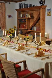 格平根霍恩斯陶芬酒店的一张长长的白色桌子,上面有蜡烛和鲜花