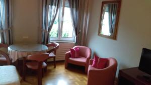 斯特拉斯堡欧朗吉里酒店的配有椅子和桌子的房间,窗户