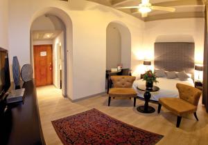 耶路撒冷巴黎圣母院中心大酒店的一间卧室配有一张床、两把椅子和一张桌子