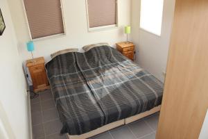 西泰尔斯海灵TS37公寓的一间卧室配有一张床,床上铺有铺着条纹毯子