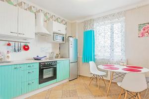 圣彼得堡Kvartira na Engelsa 138的厨房配有蓝色橱柜和桌椅
