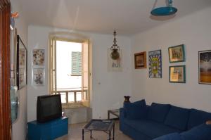 萨尔扎纳La Casa Torre di Eva的客厅配有蓝色的沙发和电视