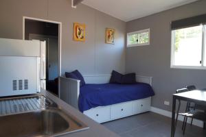 Yandina扬迪纳大篷车公园露营旅馆的一间卧室配有一张带蓝色床单和水槽的床。