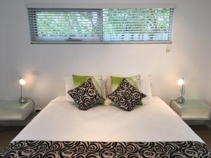 仙女港阿西莫特汽车旅馆和公寓的卧室配有带枕头的白色床和窗户。