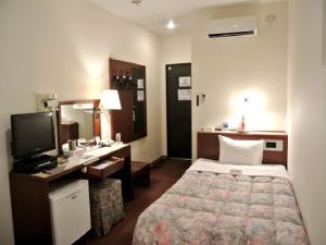 佐世保利奥广场酒店的酒店客房设有一间带一张床和一张书桌的卧室