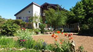 韦尔科尔地区拉沙佩勒贝利尔酒店的一座房子,前面有一个种着鲜花的花园