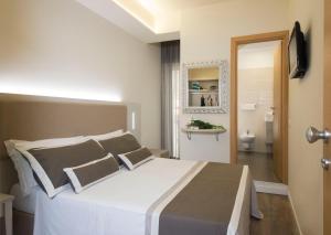 里乔内阿特拉斯酒店的一间带白色大床的卧室和一间浴室