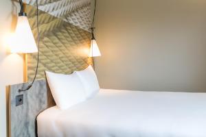 日内瓦日内瓦机场酒店的卧室配有一张带镜子的白色床