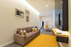 波尔图LETHESHOME Apartments的带沙发和黄色地毯的客厅