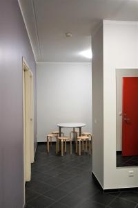 塔尔图市区旅舍的配有桌椅和红色门的房间