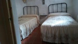 PegalajarCueva Rural La Noguera的两张睡床彼此相邻,位于一个房间里