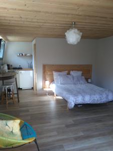 杜萨尔Le chalet du Lac的一间卧室设有一张大床和木制天花板