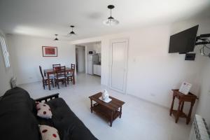 科帕韦Aparthotel Aldea Termal的客厅配有黑色沙发和桌子