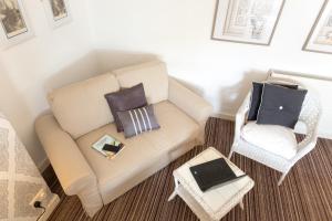曼彻斯特雅诗阁服务公寓的客厅配有沙发和带笔记本电脑的椅子