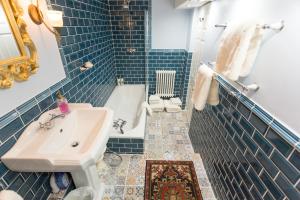 曼彻斯特雅诗阁服务公寓的蓝色瓷砖浴室设有水槽和浴缸