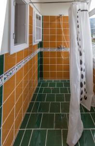 克查赫斯珀尔伯格飞度酒店的浴室铺有橙色和绿色瓷砖,配有淋浴。