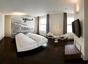 伯布林根经典摩托世界地区斯图加特V8酒店的卧室配有一张白色大床和电视。