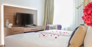 奥斯特豪特A-Hotel Oosterhout的酒店客房的床铺上摆放着两张红色玫瑰花床。