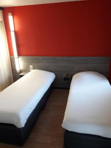 圣艾蒂安迪鲁夫赖HOTEL PREMIERE CLASSE Rouen Sud Oissel的红色墙壁的客房内的两张床