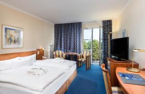 梅泽堡哈雷-梅森堡丽笙酒店的酒店客房设有一张大床和一台电视。