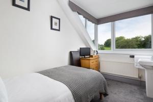 凯西克Skiddaw Croft Bed & Breakfast的一间卧室配有床、水槽和窗户