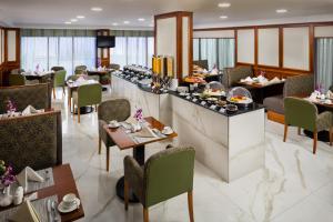 迪拜萨沃伊公园公寓酒店的餐厅设有桌椅