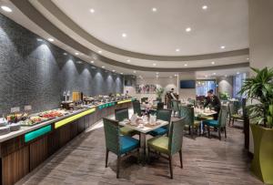 迪拜萨窝儿中央酒店公寓的一间带桌椅的用餐室和一间酒吧