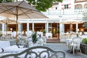 马伦格欧贝鲁耶特罗曼蒂克酒店的一间设有白色桌椅和遮阳伞的餐厅