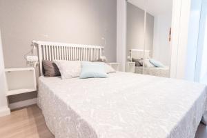 穆尔西亚Apartamento Galicia的一间卧室配有一张带白色床罩的大床