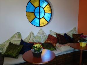 阿鲁雅Viverdi Hotel的一张带枕头的沙发和彩色玻璃窗